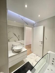 uma casa de banho branca com um lavatório e um chuveiro em Luxury Lily's apartment em Shkodër
