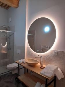 bagno con lavandino e specchio a parete di Gîte Les Muses, Ancien hôtel particulier avec SPA a Ornans