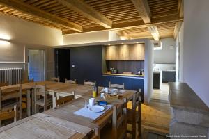 una cucina e una sala da pranzo con un grande tavolo in legno di Gîte Les Muses, Ancien hôtel particulier avec SPA a Ornans