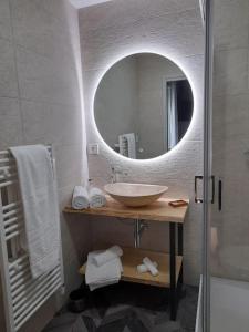 bagno con lavandino e specchio di Gîte Les Muses, Ancien hôtel particulier avec SPA a Ornans