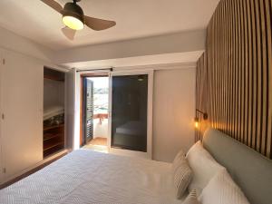 een slaapkamer met een bed en een plafondventilator bij Modern Duplex apartment near swimming pool in Mogán +78 foto's