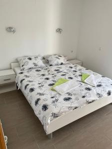 1 dormitorio con 1 cama con edredón blanco y negro en apartman Marko Malinska, en Malinska