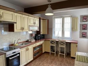 a kitchen with yellow cabinets and a sink at Apartament Centrum in Kołobrzeg