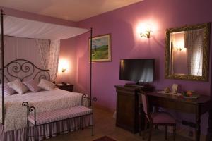 a bedroom with a bed and a desk and a mirror at Relais Osteria Dell'Orcia in Bagno Vignoni