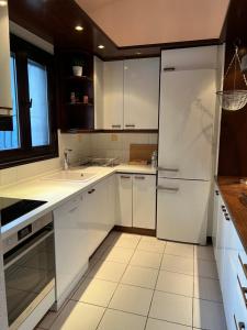 a kitchen with white cabinets and a refrigerator at Villa Diomedes in Sani Beach