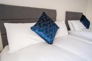 a blue and white pillow sitting on top of a bed at Luxury town apartment with roof terrace, Sleeps 6 in Blackpool