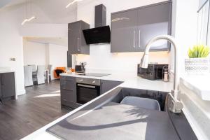 a kitchen with black and white cabinets and a sink at Luxury town apartment with roof terrace, Sleeps 6 in Blackpool