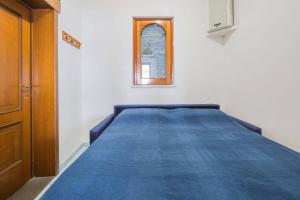 a bedroom with a blue bed with a window at La Terrazza Amalfi in Amalfi