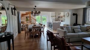 a living room with a couch and a table and chairs at Wakacyjny dom nad jeziorem 16 osób Holiday house in Szałstry