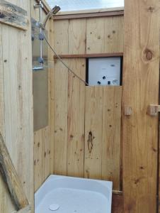 a wooden bathroom with a tub and a toilet at La Roulotte romantique des volcans in Saint-Saturnin