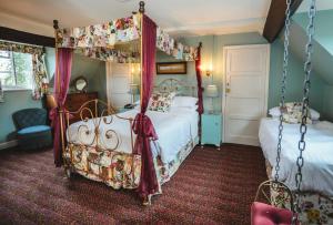 a bedroom with two beds and a canopy bed at Hundred House Hotel in Ironbridge