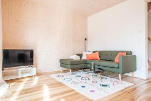 sala de estar con sofá verde y alfombra en Ferienhaus Greith79, en Kitzeck im Sausal