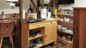 a kitchen with a wooden cabinet with dishes on it at Ferienwohnungen Vesteblick in Dörfles