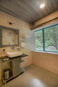 a bathroom with a sink and a mirror at SaffronStays The Elements in Kulu