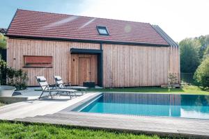 una casa con una piscina y dos sillas junto a ella en Ferienhaus Greith79, en Kitzeck im Sausal