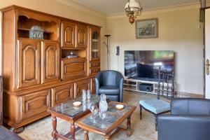 a living room with a table and a tv at Maison avec piscine pour 6 personnes in Plomeur