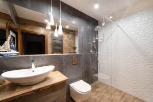 a bathroom with a sink and a glass shower at Apartament Plaża in Władysławowo