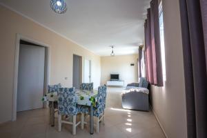 - un salon avec une table, des chaises et un canapé dans l'établissement Villa Gozhina, à Durrës
