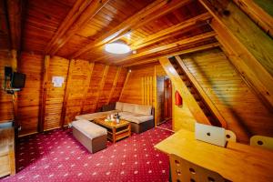 a room with a couch and a table in a cabin at Complex Malina Pamporovo in Pamporovo