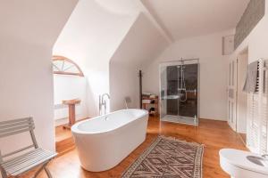 a white bathroom with a tub and a shower at 18 century Bohemian Farmhouse in Člunek