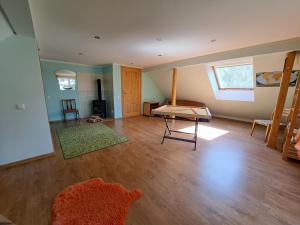 ein Wohnzimmer mit Holzboden und einem Tisch in der Unterkunft Māja ģimenes brīvdienām laukos 