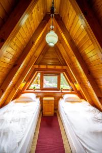 two beds in a room in a wooden attic at Complex Malina Pamporovo in Pamporovo