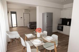a dining room and kitchen with a glass table and white chairs at Bright 2BR apartment in Palaio Faliro-(FAL_A1) in Athens