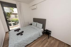 a bedroom with a large bed and a large window at Bright 2BR apartment in Palaio Faliro-(FAL_A1) in Athens