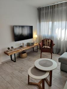 salon z telewizorem, kanapą i stołem w obiekcie SHERRY HOME w mieście Jerez de la Frontera
