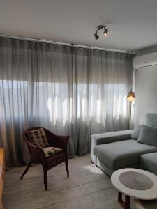salon z kanapą i krzesłem w obiekcie SHERRY HOME w mieście Jerez de la Frontera