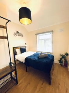 a bedroom with a bed with a blue blanket at Dwellers Delight Living 3 Bed House 2 Bathroom with Wifi & Parking in Prime Location of London Chingford Enfield Area in Chingford