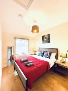 - une chambre avec un grand lit et une couverture rouge dans l'établissement Dwellers Delight Living 3 Bed House 2 Bathroom with Wifi & Parking in Prime Location of London Chingford Enfield Area, à Chingford