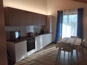 a kitchen with a table and a kitchen with a microwave at Ciasa Erica - Val di Non in Predaia