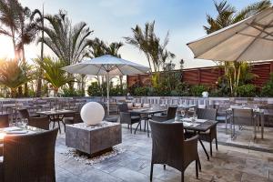 un ristorante con tavoli e sedie e un ombrellone di JW Marriott Hotel Cairo a Il Cairo