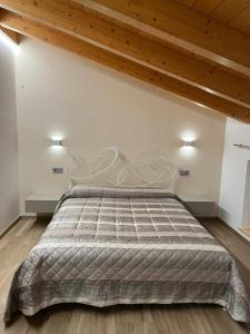 a large bed in a room with a wooden ceiling at Ciasa Erica - Val di Non in Predaia
