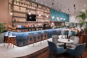 a bar in a restaurant with chairs and a counter at Courtyard by Marriott London Gatwick Airport in Horley