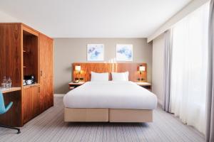 a bedroom with a large bed and a large window at Courtyard by Marriott London Gatwick Airport in Horley