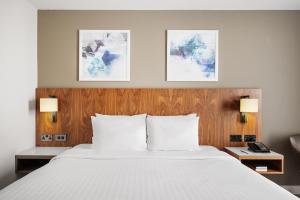 a bed in a hotel room with two lamps at Courtyard by Marriott London Gatwick Airport in Horley