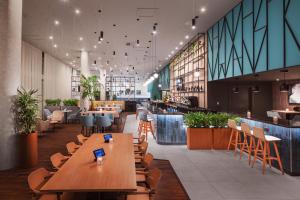 a restaurant with wooden tables and chairs in a building at Courtyard by Marriott London Gatwick Airport in Horley