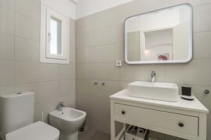 a bathroom with a toilet and a sink and a mirror at Sunset Village 5 in Paleochori