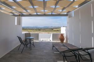 a patio with tables and chairs and a view of the desert at Sunset Village 5 in Paleochori