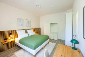 Un dormitorio con una cama verde y blanca y una mesa en 75qm Luxusapartment in perfekter Lage en Bochum
