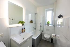 a white bathroom with a sink and a toilet at 75qm Luxusapartment in perfekter Lage in Bochum