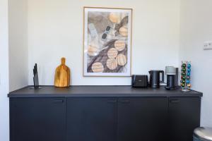 a black cabinet in a room with a picture on the wall at 75qm Luxusapartment in perfekter Lage in Bochum