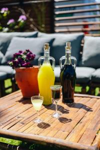 einen Holztisch mit zwei Gläsern und Flaschen Wein in der Unterkunft Maison Bellefleur B&B - Pension in Renesse