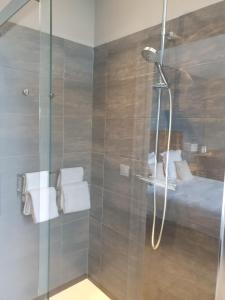 a shower with a glass door with a bed at La Fraîchette-Hôtel & Spa in Honfleur