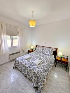una camera con un letto e un piumone blu e bianco di Emma's Place, 2 bedroom apartment with pool view a Paphos