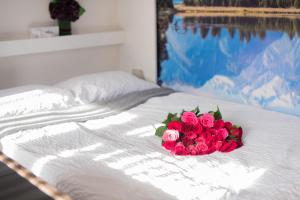 Um ramo de rosas cor-de-rosa sentado numa cama em 1 Bedroom Guest House with Sauna and Steam Room em Kent