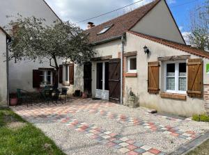 ein kleines weißes Haus mit einer Terrasse davor in der Unterkunft La grange du Ruet in Saint-Hilaire-Saint-Mesmin