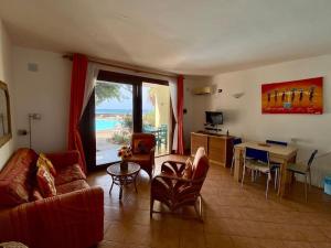un soggiorno con divano e tavolo di Porto Antigo - Charming & peaceful apartment overlooking pool and sea a Santa Maria